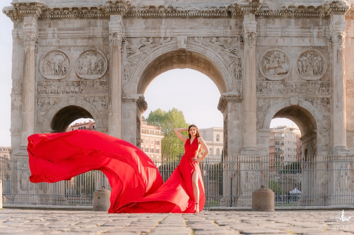 Posa flying dress The Diva: posa da editoriale con lo strascico rosso che attraversa l'inquadratura, Arco di Costantino, Roma