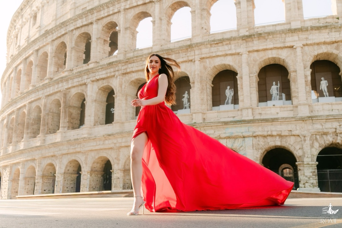 Posa flying dress The Run: corsa leggera con i capelli in movimento e la gonna rossa che si avvolge, Colosseo, Roma